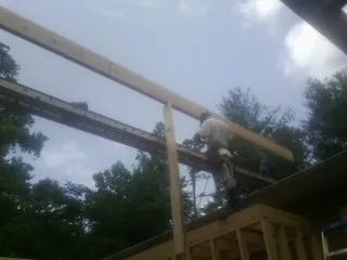 Carpenter setting a ridge beam over a new addition frame — Ice Dam Removal by Roofing Brothers in Shirley